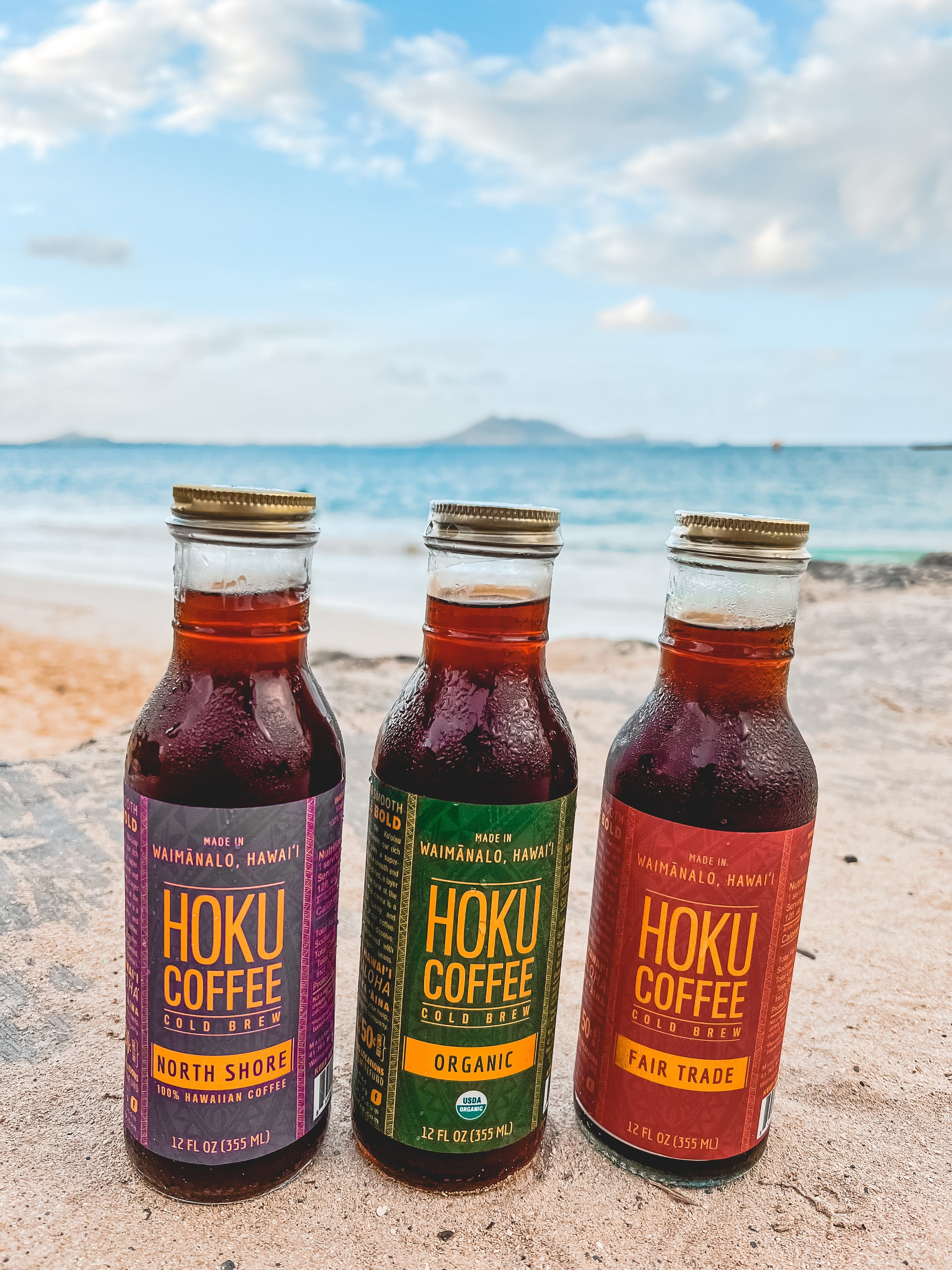 North Shore, Organic, and Fair Trade Hoku bottles on the beach